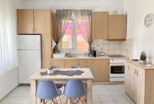 a kitchen with a table and some blue chairs at Mokamvilia House in Ammouliani