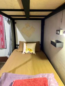 a small bedroom with a bed in a room at Little Hostel in Ban Houayxay