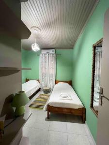 um quarto com duas camas num quarto com paredes verdes em Country House em Karlovasi