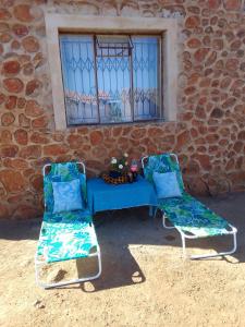 Rosslyn的住宿－KGOLA SAFARIS，两把椅子和一张蓝色桌子,位于大楼前