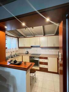 uma cozinha com armários brancos e um balcão de madeira em Country House em Karlovasi
