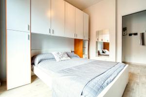 a bedroom with a large bed with white cabinets at Soggiornare sul Naviglio in Milan