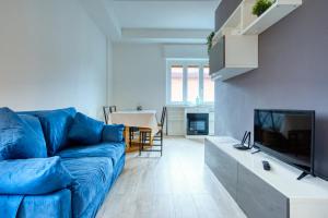 a living room with a blue couch and a tv at Soggiornare sul Naviglio in Milan