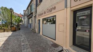 uma rua com uma loja com uma porta num edifício em L'Entracte - Appart Hôtel - Hypercentre em La Ferté-Alais
