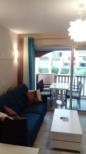 ein Wohnzimmer mit einem blauen Sofa und einem Tisch in der Unterkunft Au petit bonheur in Sanary-sur-Mer