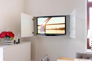 a living room with a flat screen tv on a wall at Helle Stuuv in Lemkenhafen auf Fehmarn