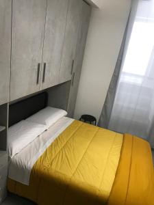 een slaapkamer met een bed met een gele deken bij Nel borgo di Capri Leone in Capri Leone