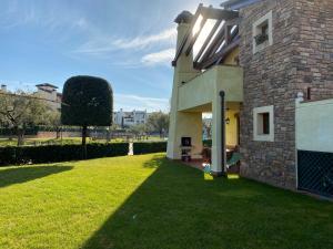 a house with a grass yard next to a building at Garda Resort Village in Peschiera del Garda