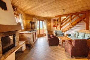 a living room with a fireplace in a log cabin at Chalet Le Wapiti, aux pieds des pistes, à 200m du village in Notre-Dame-de-Bellecombe
