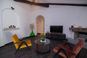 a living room with chairs and a table and a television at Apartment Valdarke A3 in Veli Lošinj