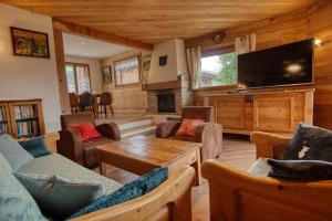 a living room filled with furniture and a flat screen tv at Chalet Le Wapiti, aux pieds des pistes, à 200m du village in Notre-Dame-de-Bellecombe