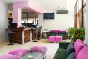 una sala de estar con muebles de color rosa y un bar en Akladi Family Hotel en Chernomorets