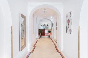 a hallway with white walls and an archway at Self-Check-In Hotel Adlon in Vienna
