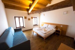 1 dormitorio con 1 cama y 1 sofá en una habitación en Borgo Case Marian, en Cison di Valmarino