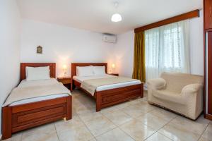 - une chambre avec deux lits, une chaise et une fenêtre dans l'établissement Kiriakos Holiday Home, à Astris