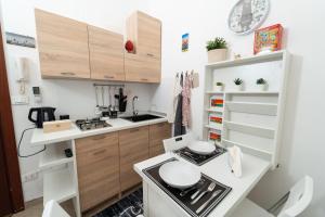 een kleine keuken met houten kasten en een fornuis bij Le Casette di Didi in Trapani