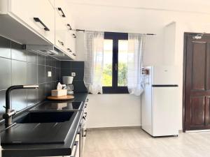 une cuisine avec un évier noir et un réfrigérateur dans l'établissement PRIMAVERA, à Kalamaki 28 autres photos