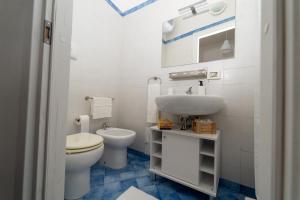 een witte badkamer met een toilet en een wastafel bij Le Casette di Didi in Trapani +34 foto's