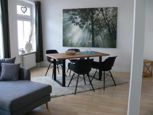 ein Wohnzimmer mit einem Holztisch und Stühlen in der Unterkunft Stilvolle Ferienwohnungen im Zentrum von Schwerin in Schwerin