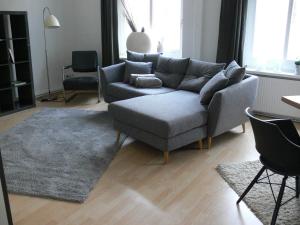 a living room with a grey couch and a rug at Stilvolle Ferienwohnungen im Zentrum von Schwerin in Schwerin