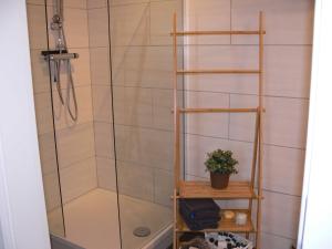 y baño con ducha y estante de madera. en Stilvolle Ferienwohnungen im Zentrum von Schwerin, en Schwerin