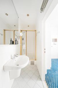 a white bathroom with a sink and a shower at Self-Check-In Hotel Adlon in Vienna