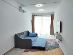 sala de estar con sofá y TV en Homestay Studio Apartment Bentara Suite, Kompleks Mutiara Gua Musang, en Gua Musang