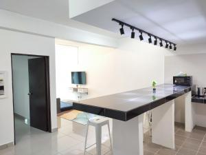 cocina con encimera negra en una habitación en Homestay Studio Apartment Bentara Suite, Kompleks Mutiara Gua Musang, en Gua Musang