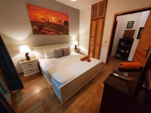 Un dormitorio con una cama blanca y una pintura en la pared en Beautiful apartement in the heart of tangier, en Tánger