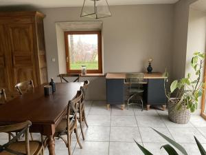 ein Esszimmer mit einem Tisch, Stühlen und einem Fenster in der Unterkunft Logement dans maison + extérieur in Orchamps-Vennes
