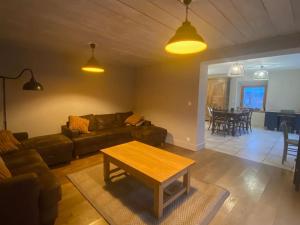 uma sala de estar com um sofá e uma mesa em Logement dans maison + extérieur em Orchamps-Vennes