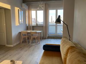 een woonkamer met een bank en een tafel met stoelen bij Apartament Zachody nad Wrocławiem in Wrocław