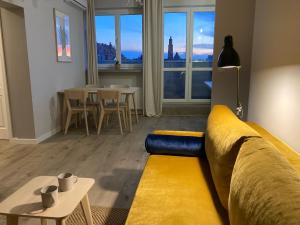 een woonkamer met een gele bank en een tafel bij Apartament Zachody nad Wrocławiem in Wrocław