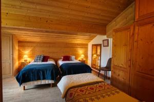 a bedroom with two beds in a log cabin at Chalet Le Wapiti, aux pieds des pistes, à 200m du village in Notre-Dame-de-Bellecombe