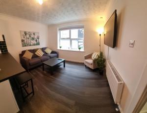 a living room with a couch and a tv at Newly refurbished Falmouth town centre apartment in Falmouth