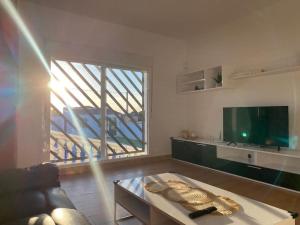 a living room with a couch and a large window at Villa "El Salao" in Chiclana de la Frontera