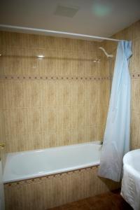 a bathroom with a bath tub and a sink at Apartamentos Turisticos Aureus Bahia Sur in La Línea de la Concepción