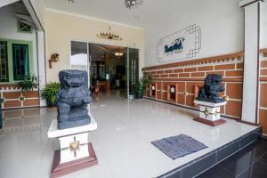 a lobby with two statues on display in a building at RedDoorz near Kartini Mall Lampung in Bandar Lampung