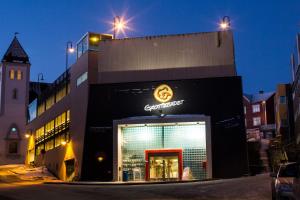 a store with a sign on the side of a building at Scandic Harstad in Harstad