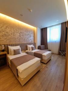 Habitación de hotel con 2 camas y sofá en Hotel Emerald, en Mostar