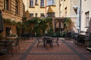 an outdoor patio with tables and chairs and buildings at Stabu Sēta Apartments in Riga