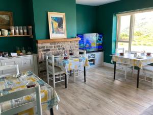 a dining room with two tables and a fireplace at Robins Nest in Ardara