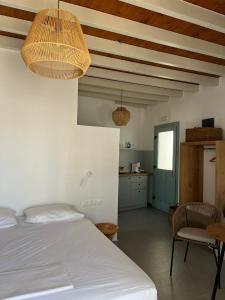 a bedroom with a bed and a table and a kitchen at Arhodiko Studios in Astypalaia