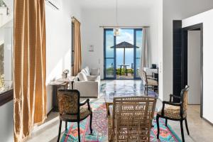 アサニオンにあるSerenity Boutique Suitesのリビングルーム(椅子、テーブル、ソファ付)