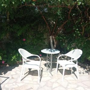 two chairs and a table and a table and two chairs at Soustas Apartments in Longos