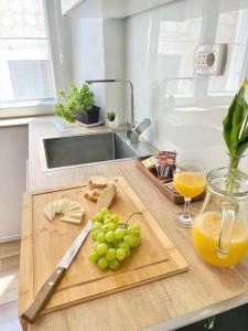 a kitchen with a cutting board with grapes and a glass of orange juice at Luxury apartment Aura in Supetar