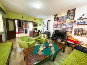 a living room with green furniture and a television at Hi Skopje Hostel in Skopje
