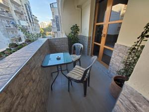 丹吉爾的住宿－Beautiful apartement in the heart of tangier，阳台配有一张蓝色的桌子和两把椅子
