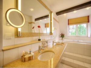 ein Badezimmer mit zwei Waschbecken und einem großen Spiegel in der Unterkunft Trip Inn Hotel Der Adelshof in Schwäbisch Hall