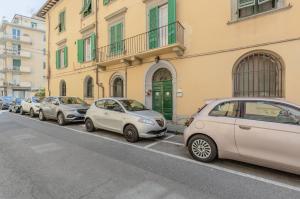 una fila di auto parcheggiate sul lato di una strada di Tuttomondo Central Flat with Private Courtyard a Pisa